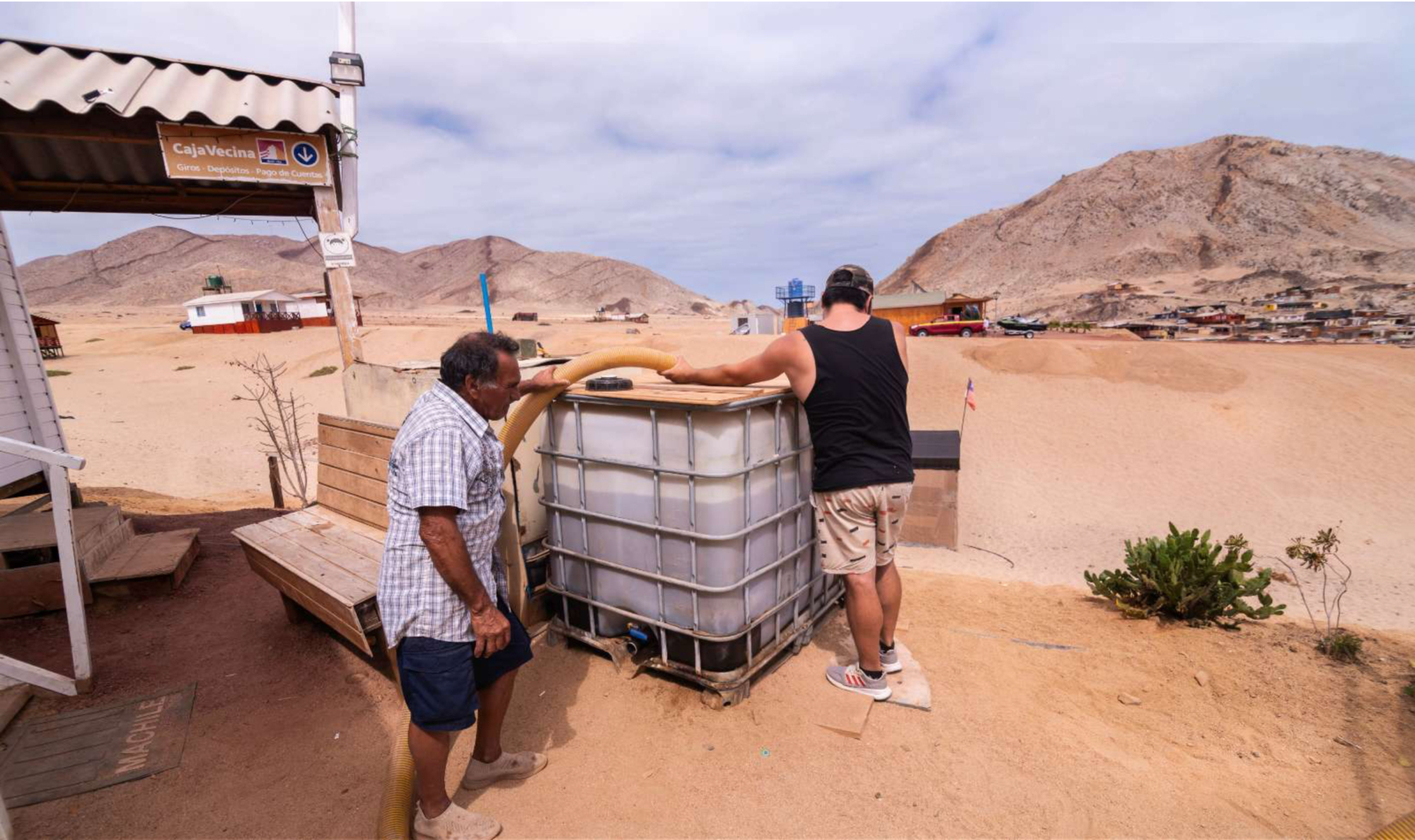 Dos hombres llenan depósito de agua en desierto