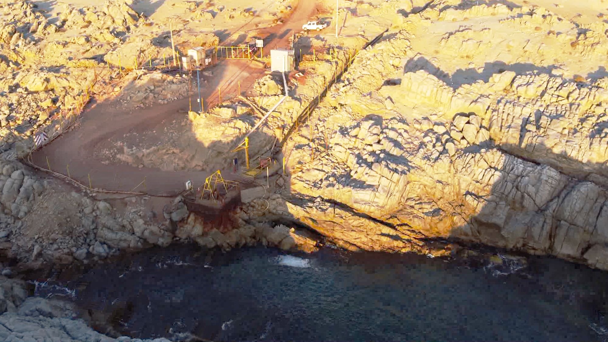 Instalación vallada en costa rocosa junto al mar