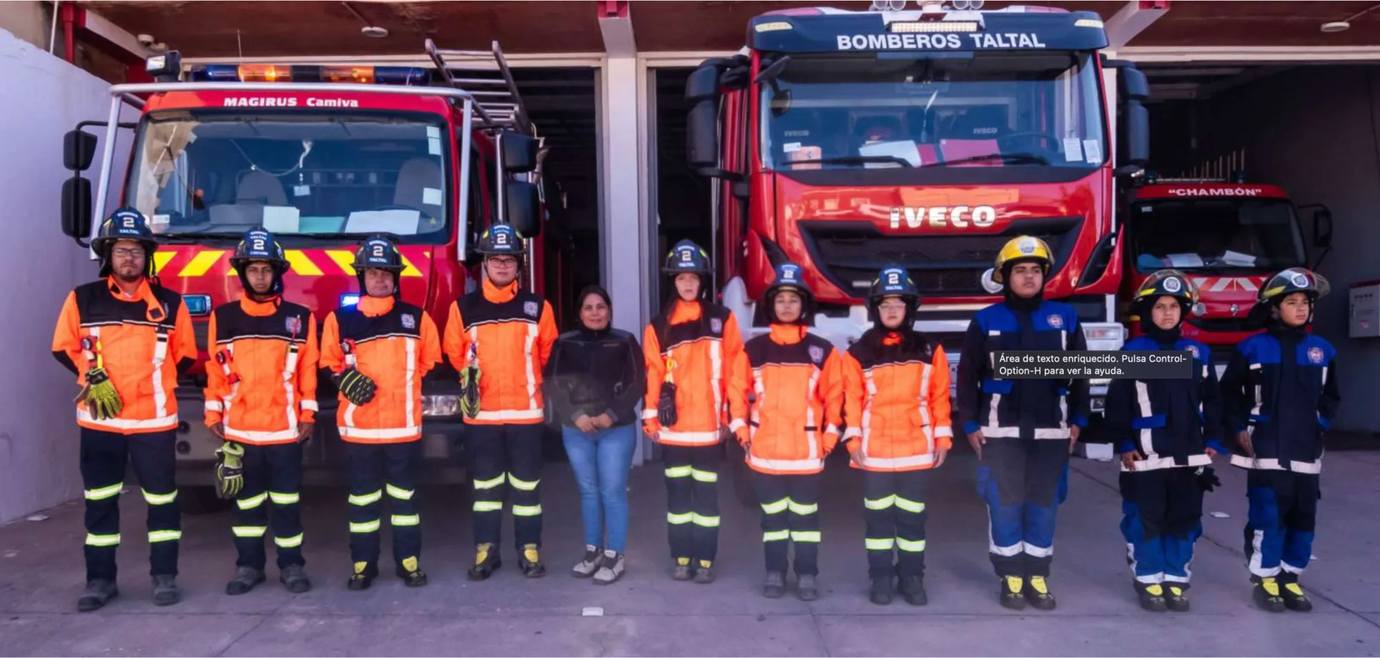 Bomberos posan frente a camiones en parque