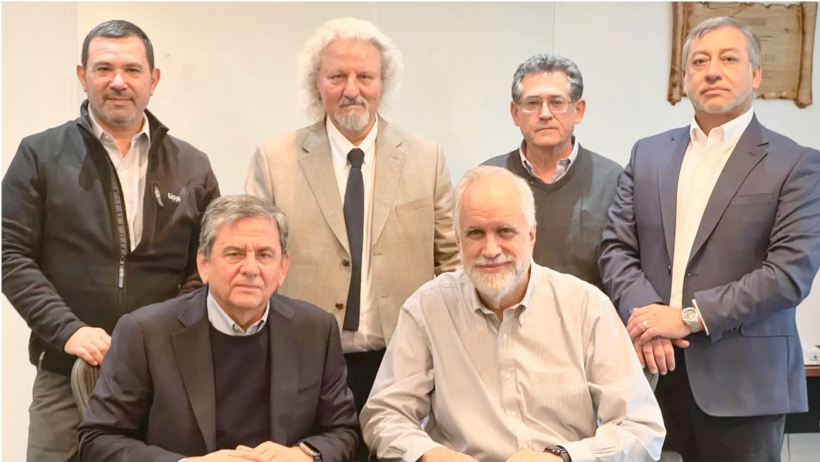 Seis hombres posando en una oficina