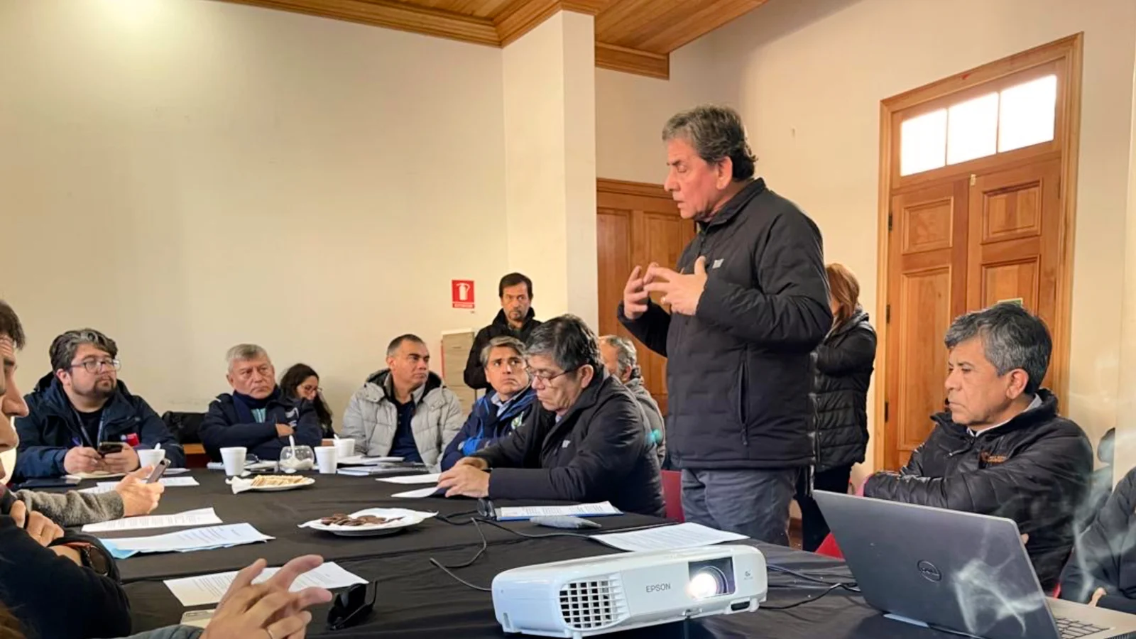 Hombre habla en reunión con equipo de trabajo