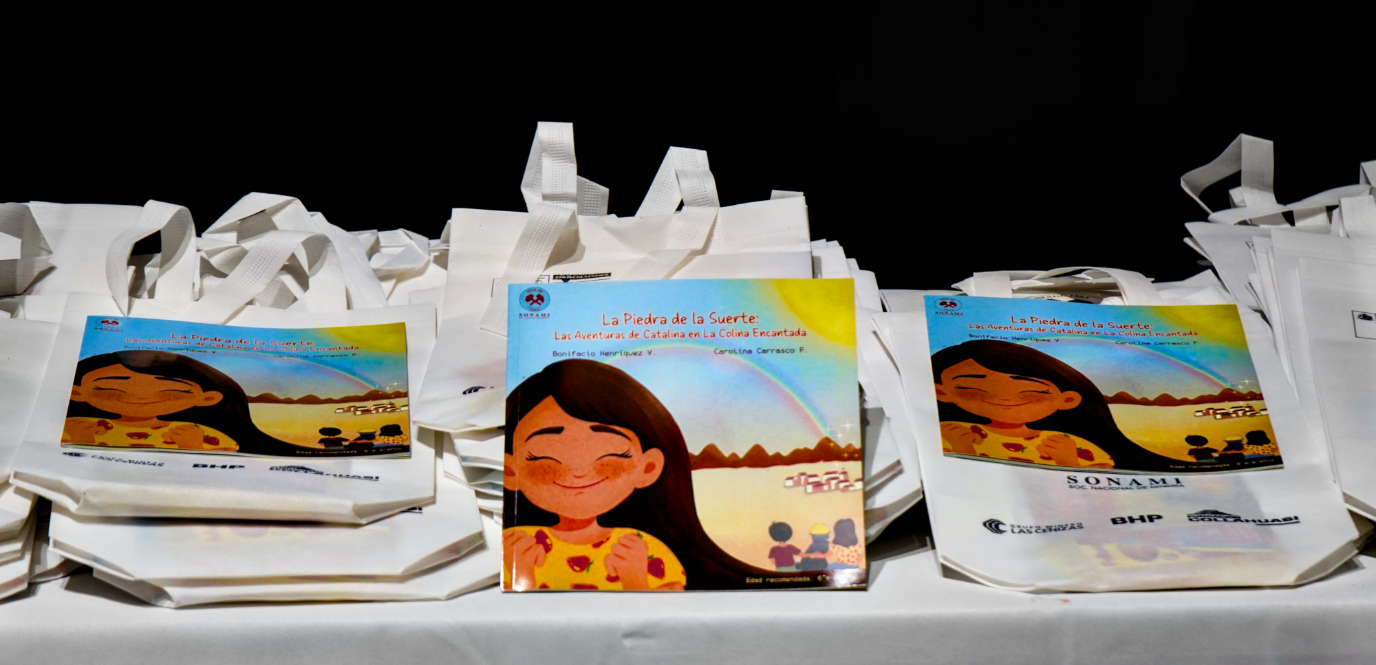 Libros infantiles expuestos sobre bolsas blancas promocionales