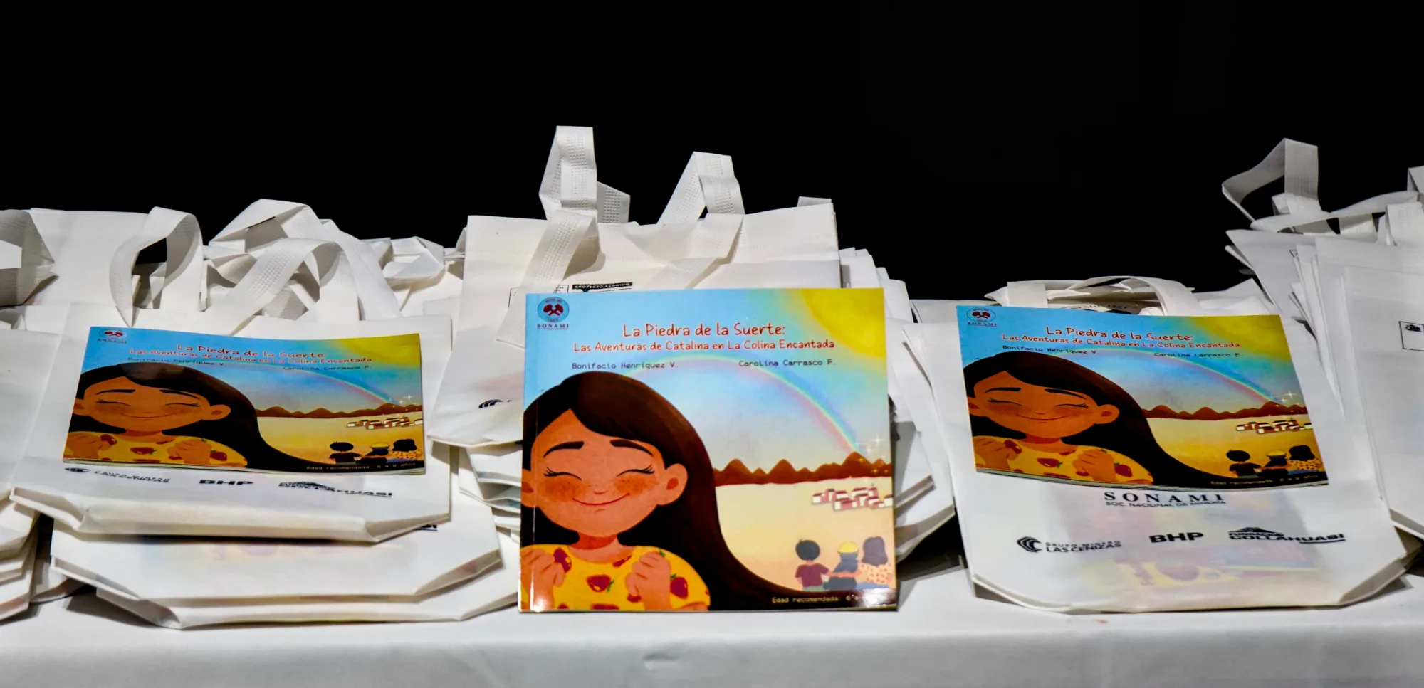 Libros infantiles expuestos sobre bolsas blancas promocionales