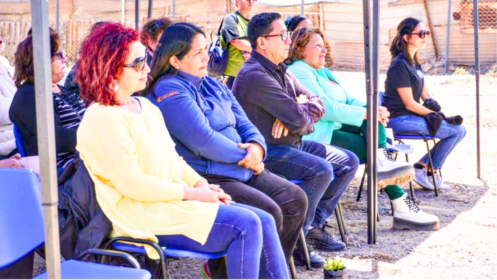 Grupo de adultos sentados en evento al aire libre