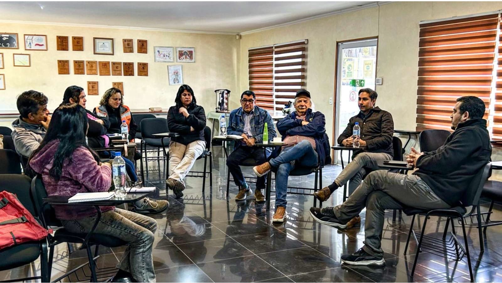 Grupo de personas reunidas en círculo en sala
