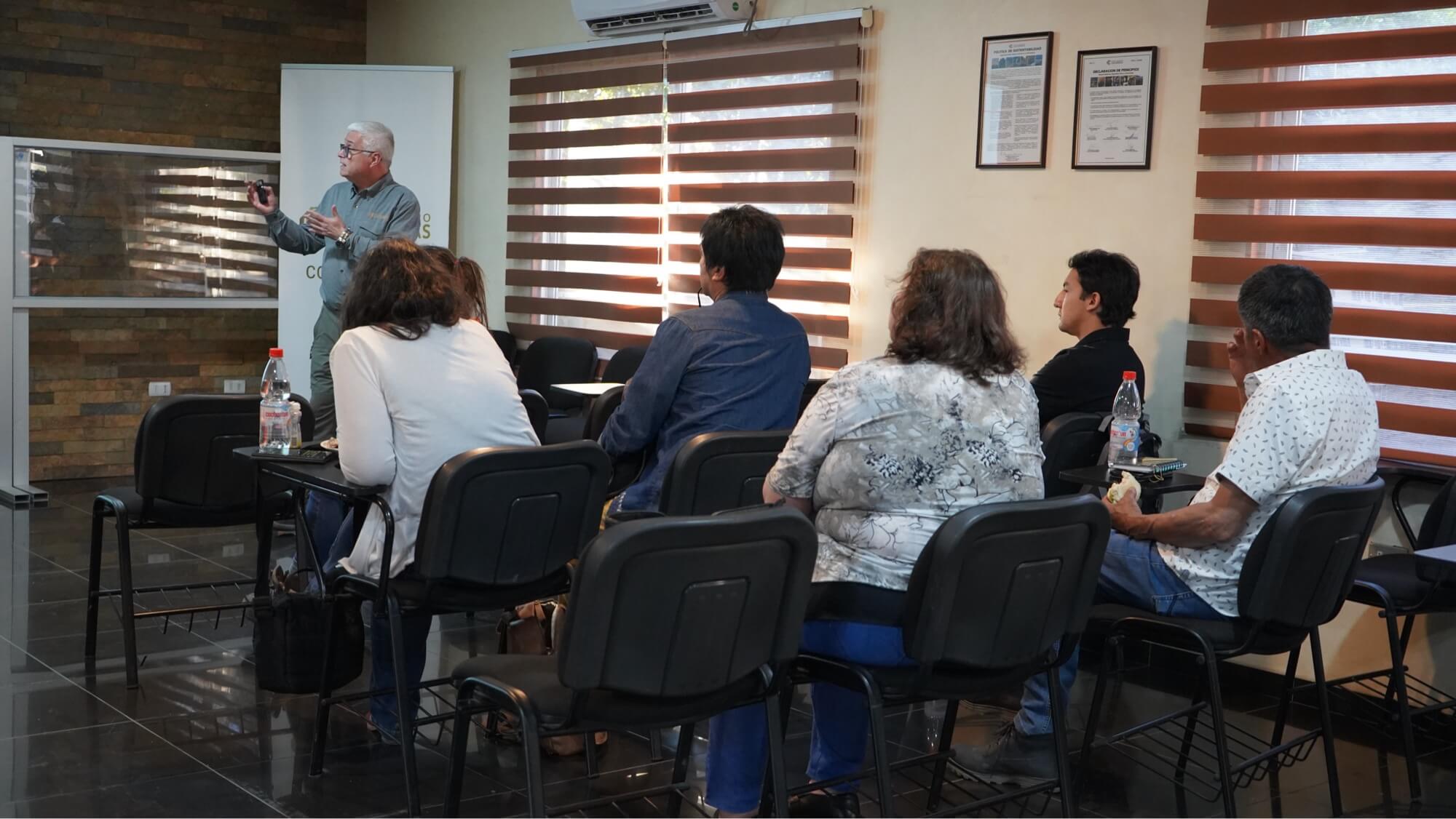 Ponente explicando ante público en sala de reuniones