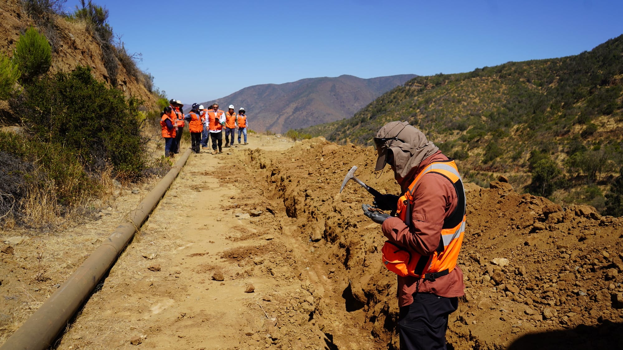 Trabajadores inspeccionan tubería en camino de montaña