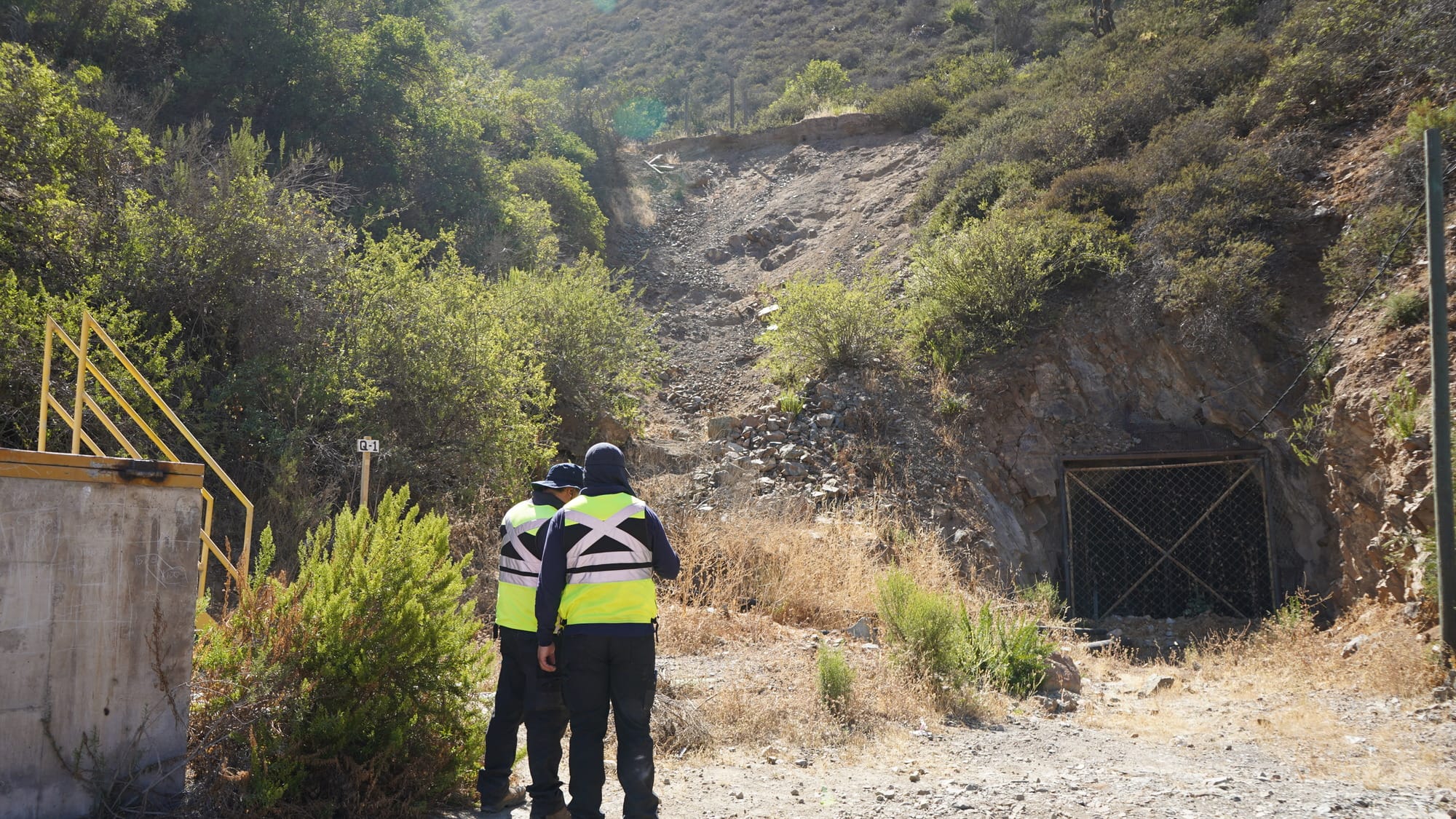 Trabajadores inspeccionan entrada de túnel en colina