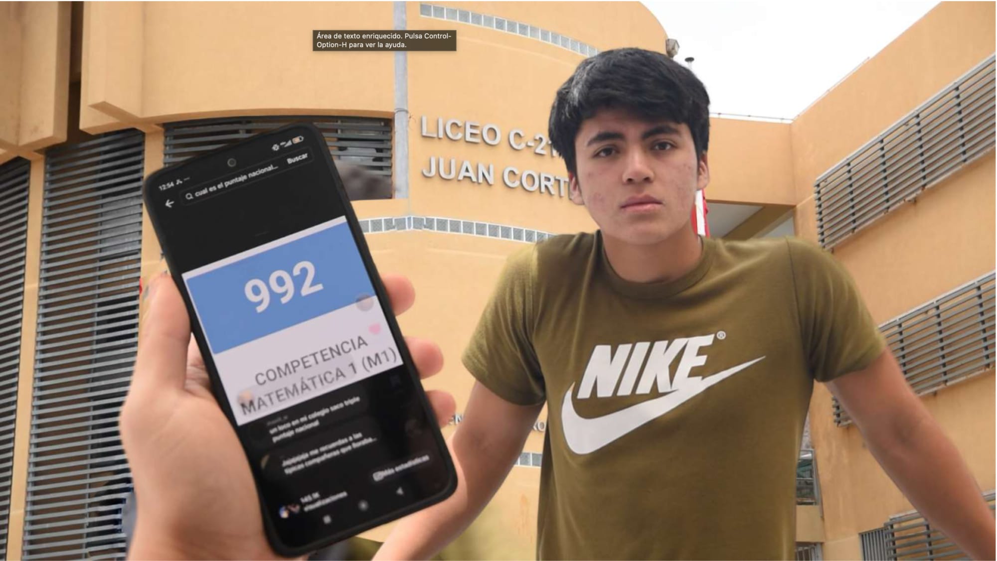 Estudiante frente a liceo mostrando puntuación 992