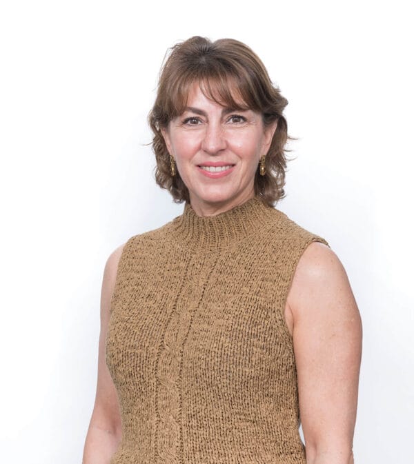 Mujer sonriente con blusa marrón sin mangas