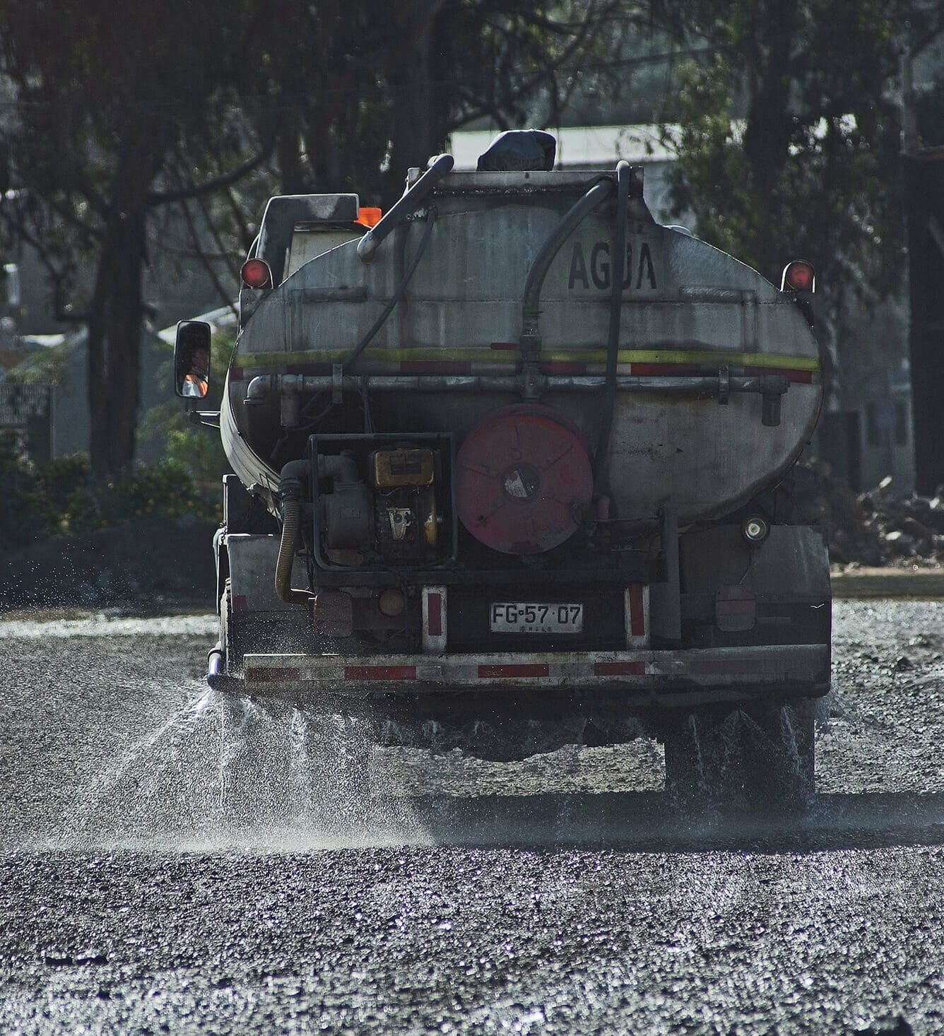 Camión cisterna rociando agua en carretera