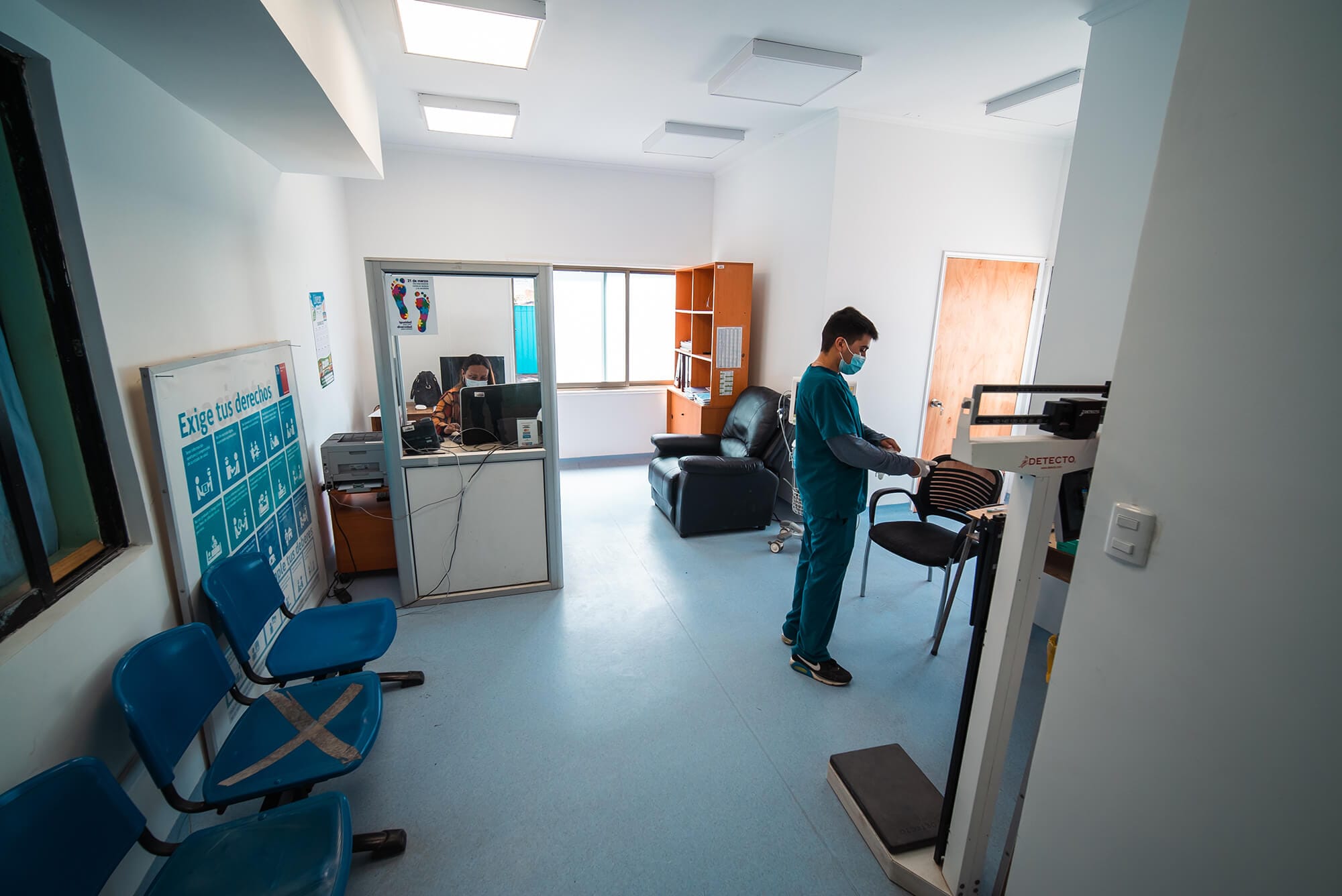 Consulta médica con profesional ajustando báscula