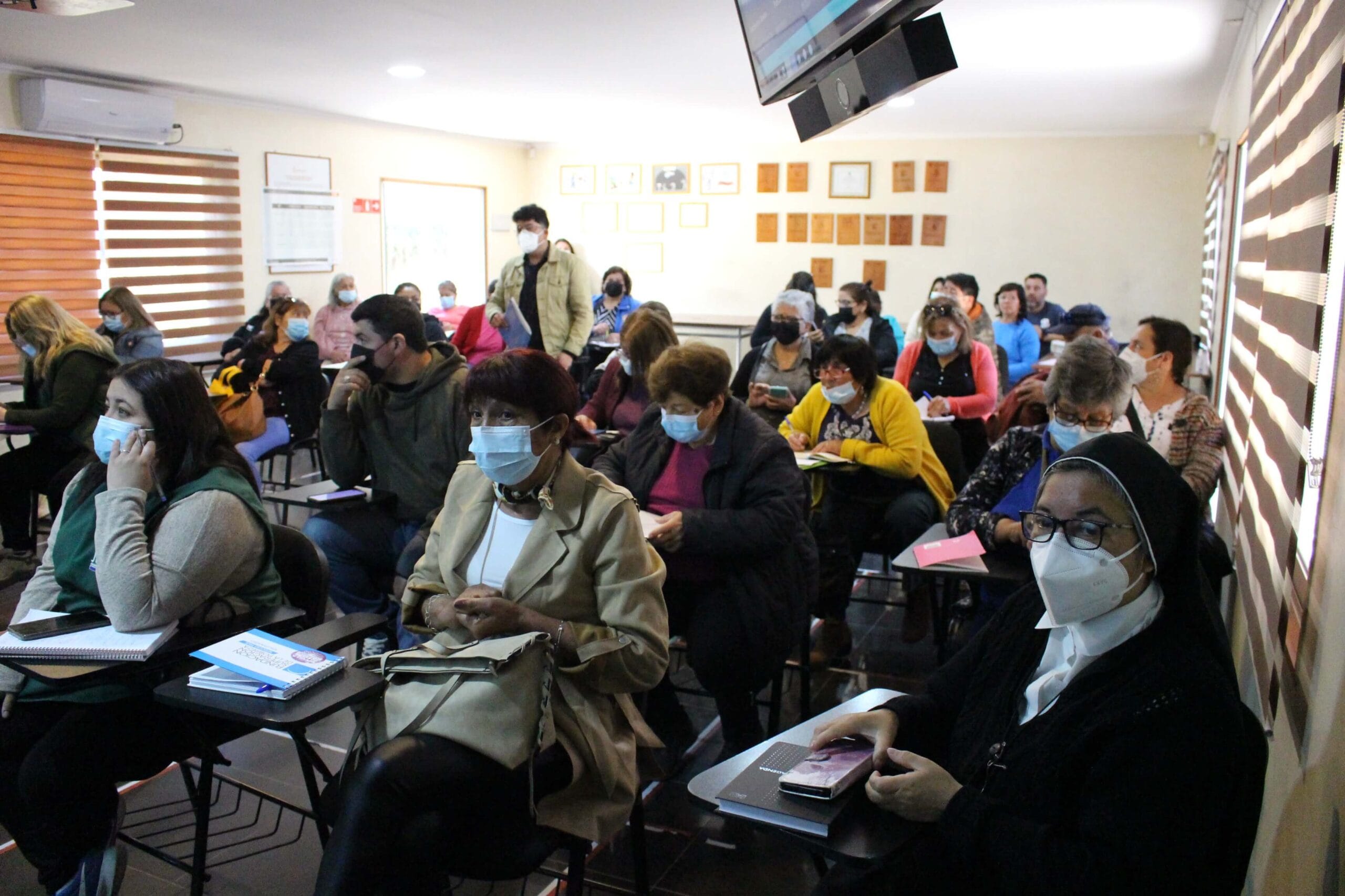 Aula con adultos con mascarilla en clase