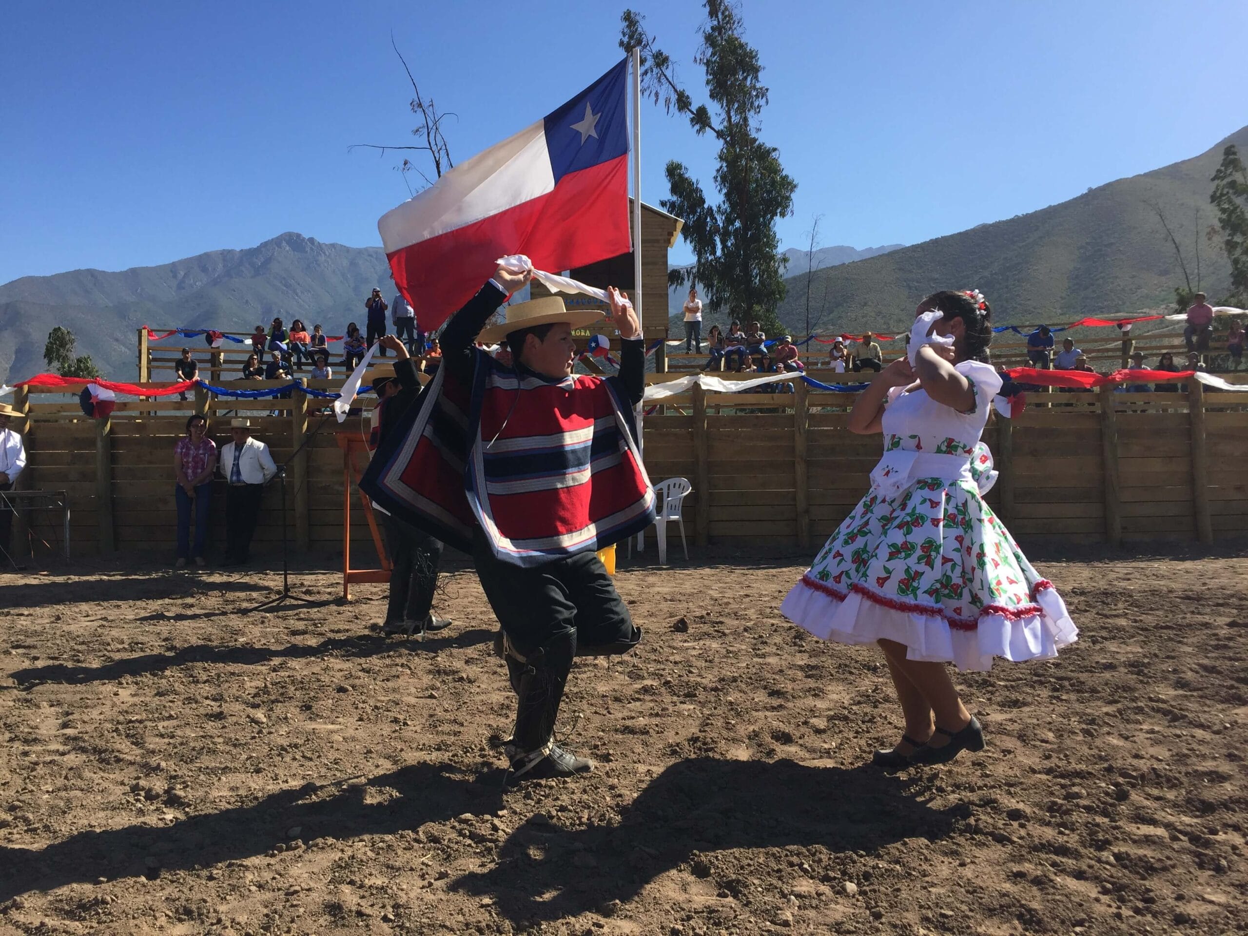 Niños bailando cueca con bandera de Chile