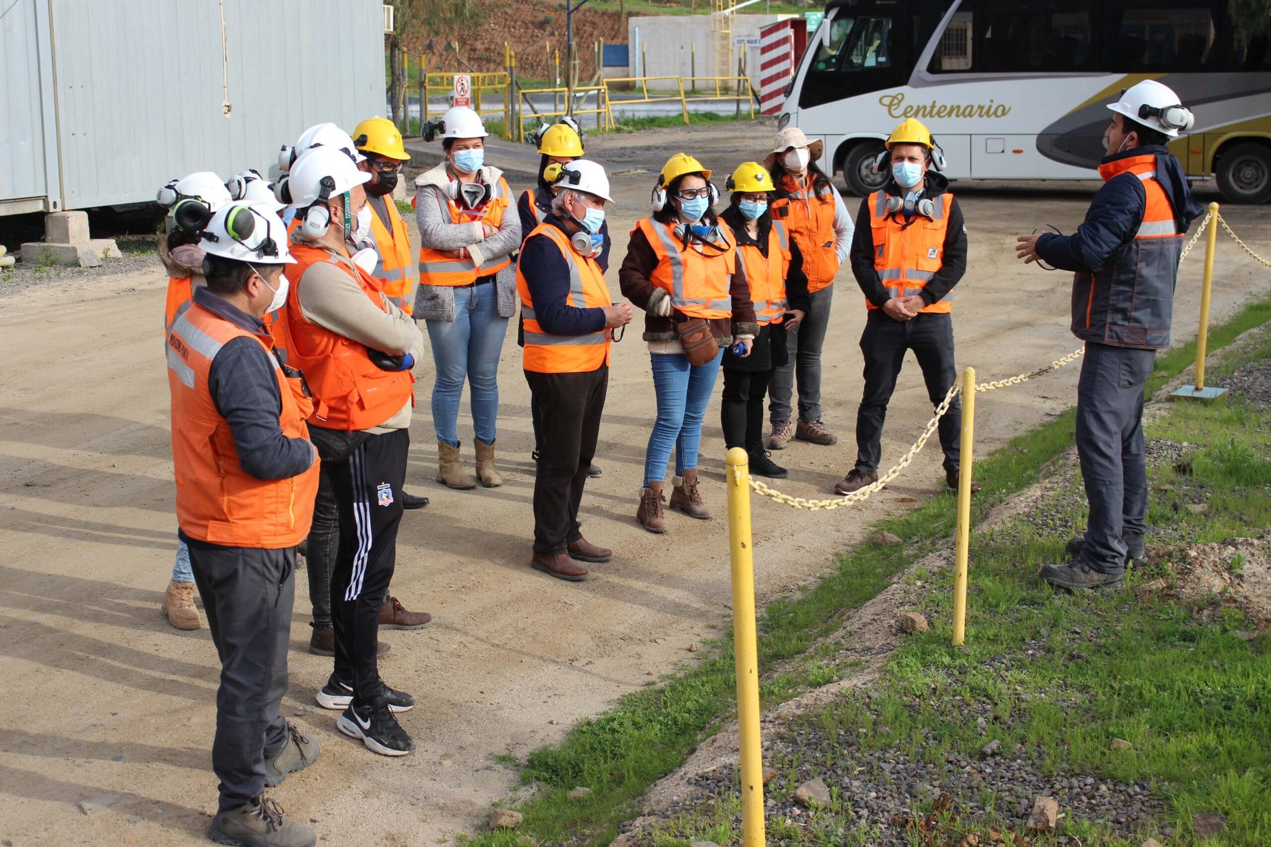 Trabajadores con casco en charla de seguridad industrial