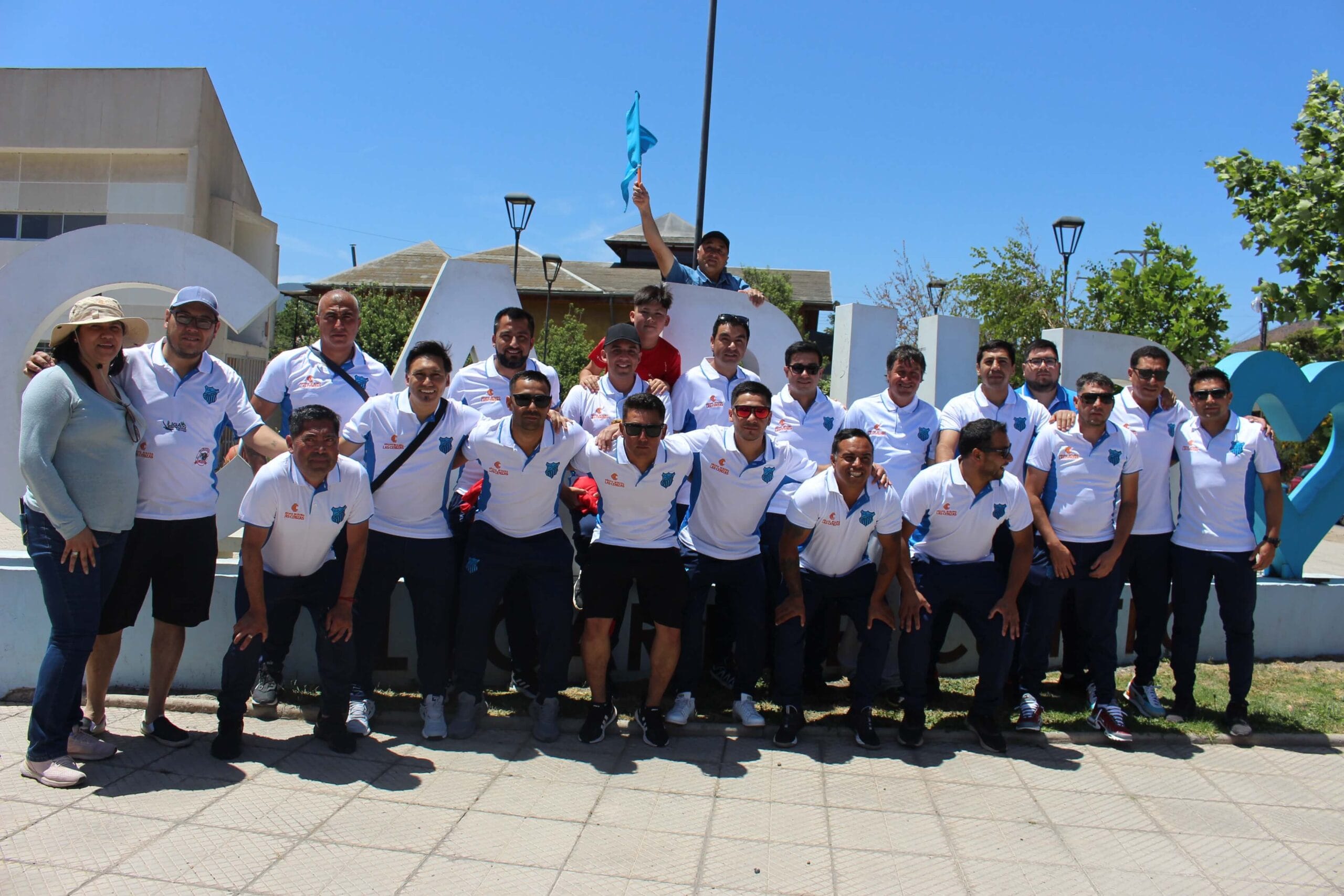 Equipo posando frente a letras monumentales urbanas