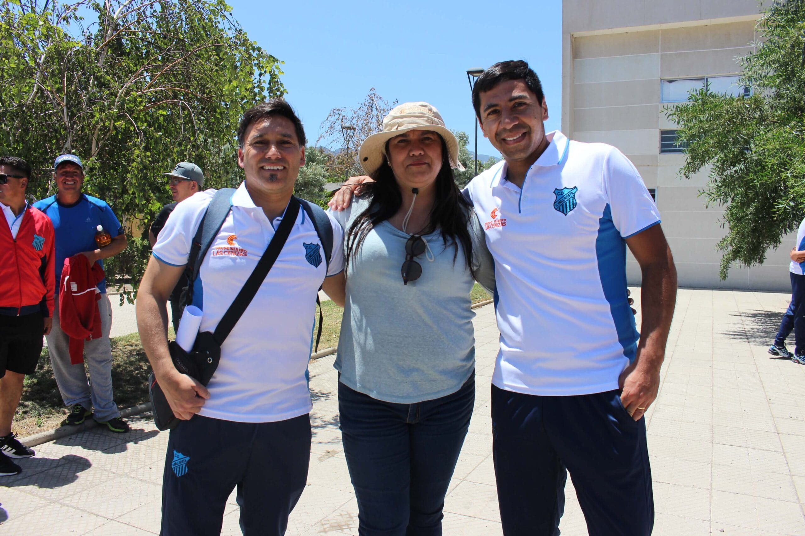 Tres personas posan juntas al aire libre