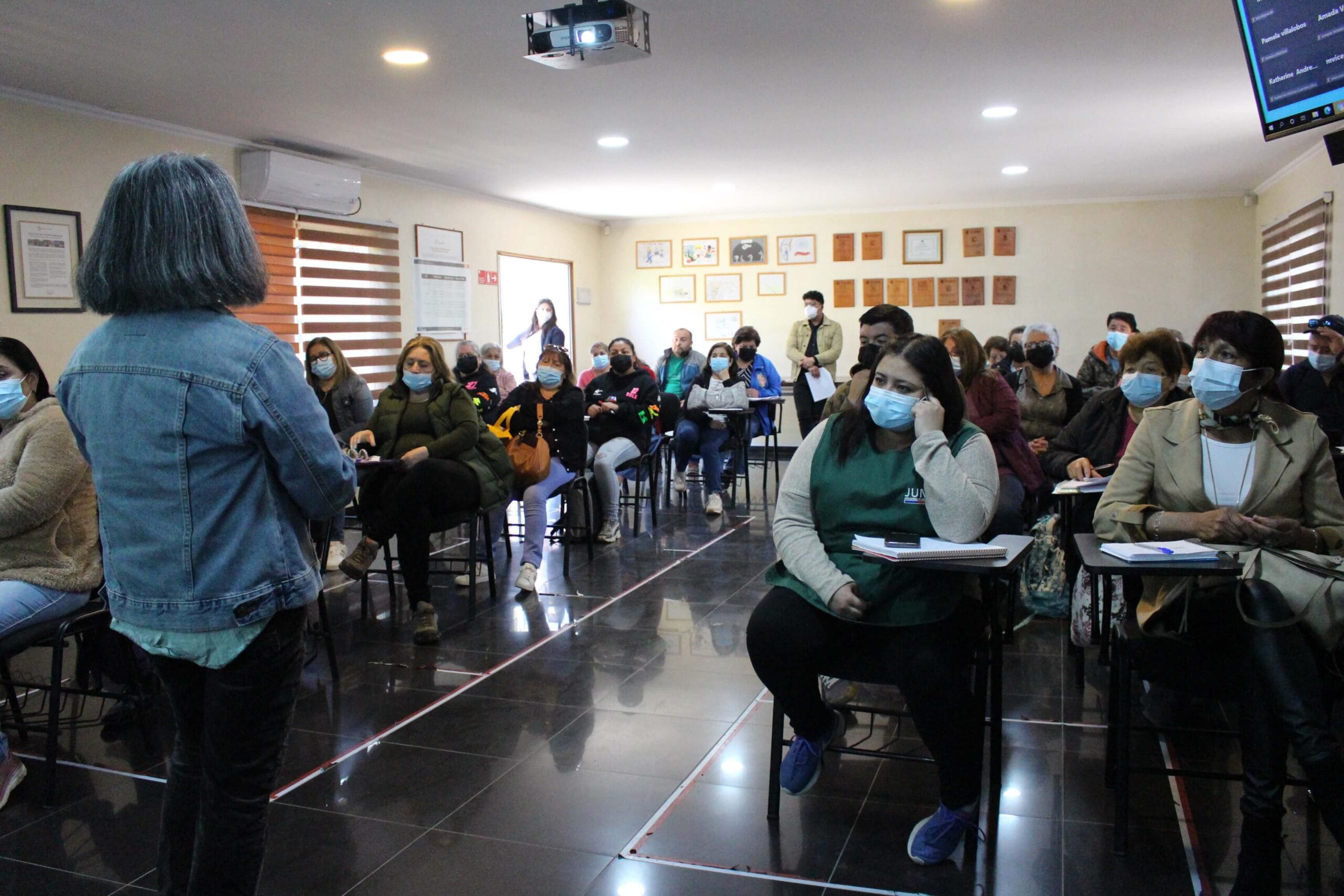 Charla formativa con asistentes sentados y mascarillas