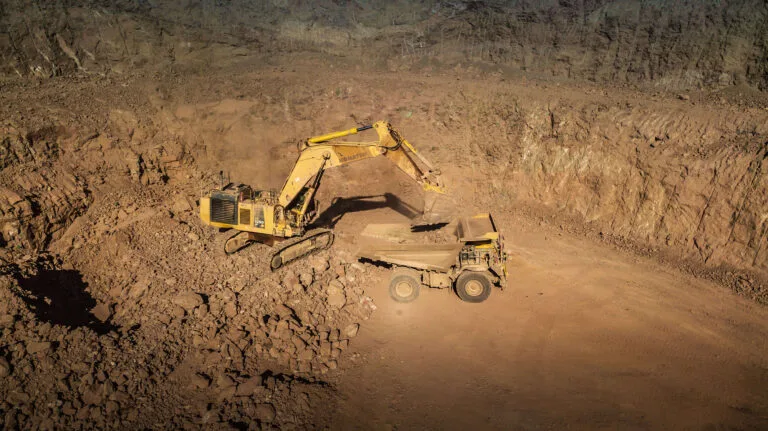 Excavadora cargando camión en cantera a cielo abierto