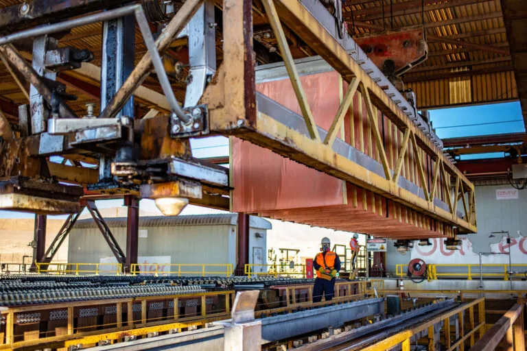 Operario bajo puente grúa en planta industrial