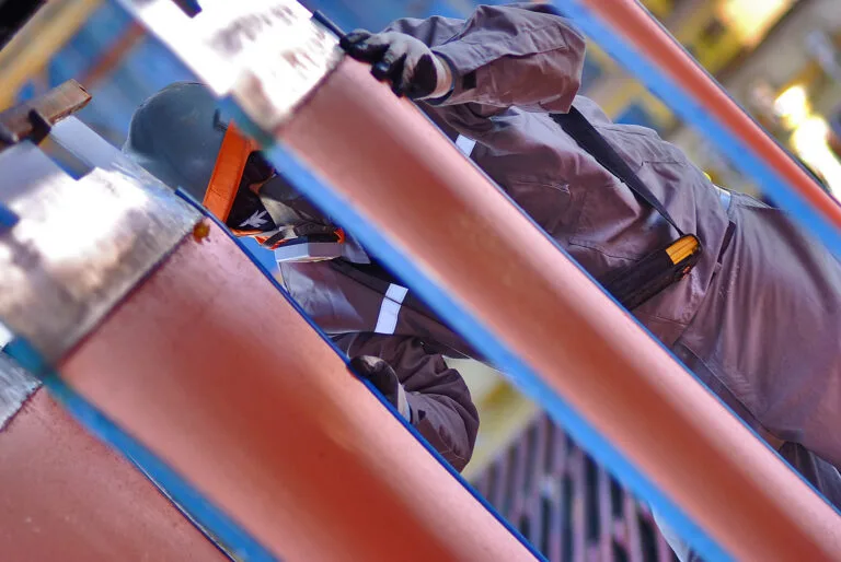 Trabajador con equipo de protección inspecciona tuberías industriales