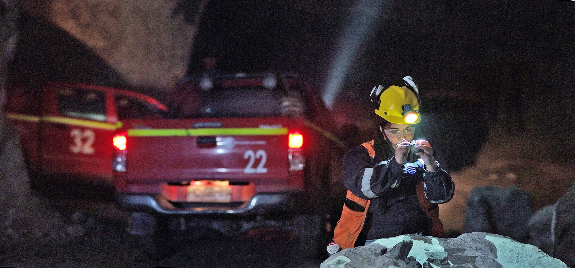 Minero examinando rocas en túnel subterráneo