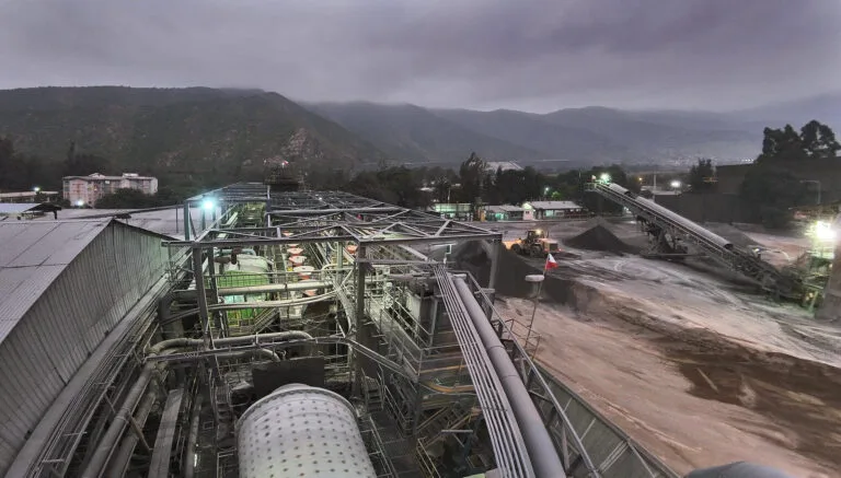 Planta industrial minera con cintas transportadoras al atardecer
