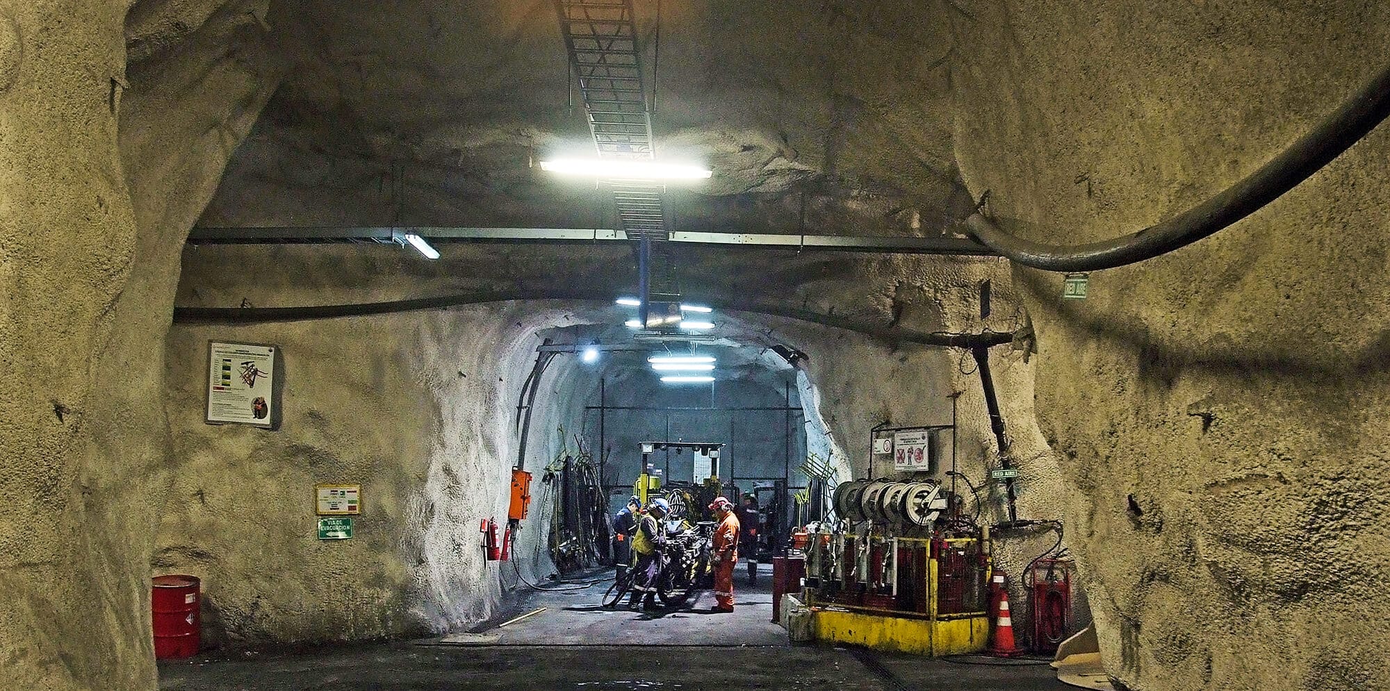 Trabajadores en túnel subterráneo industrial iluminado