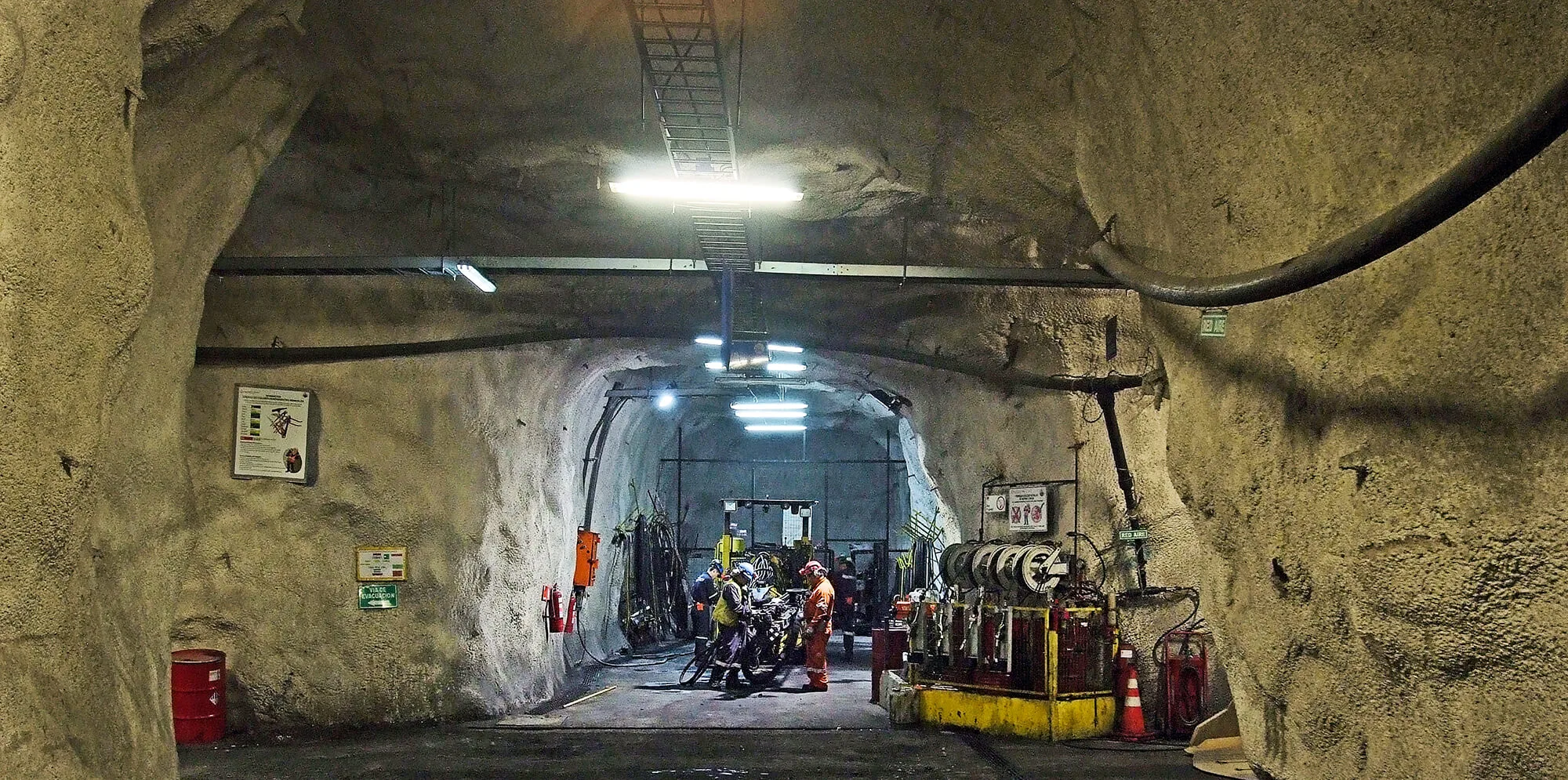 Trabajadores en túnel subterráneo industrial iluminado