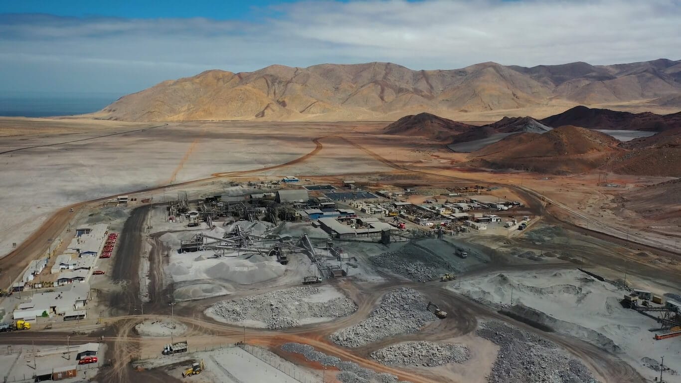 Instalación minera en desierto con montañas al fondo