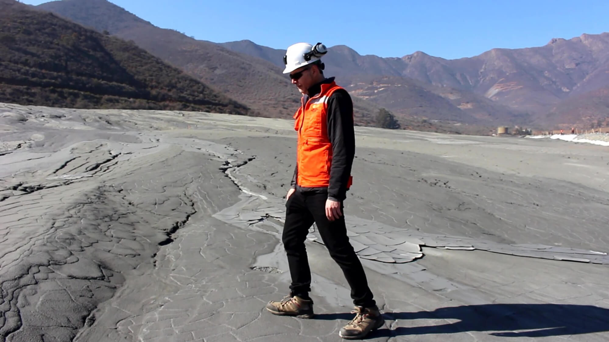 Trabajador con casco sobre terreno agrietado montañoso