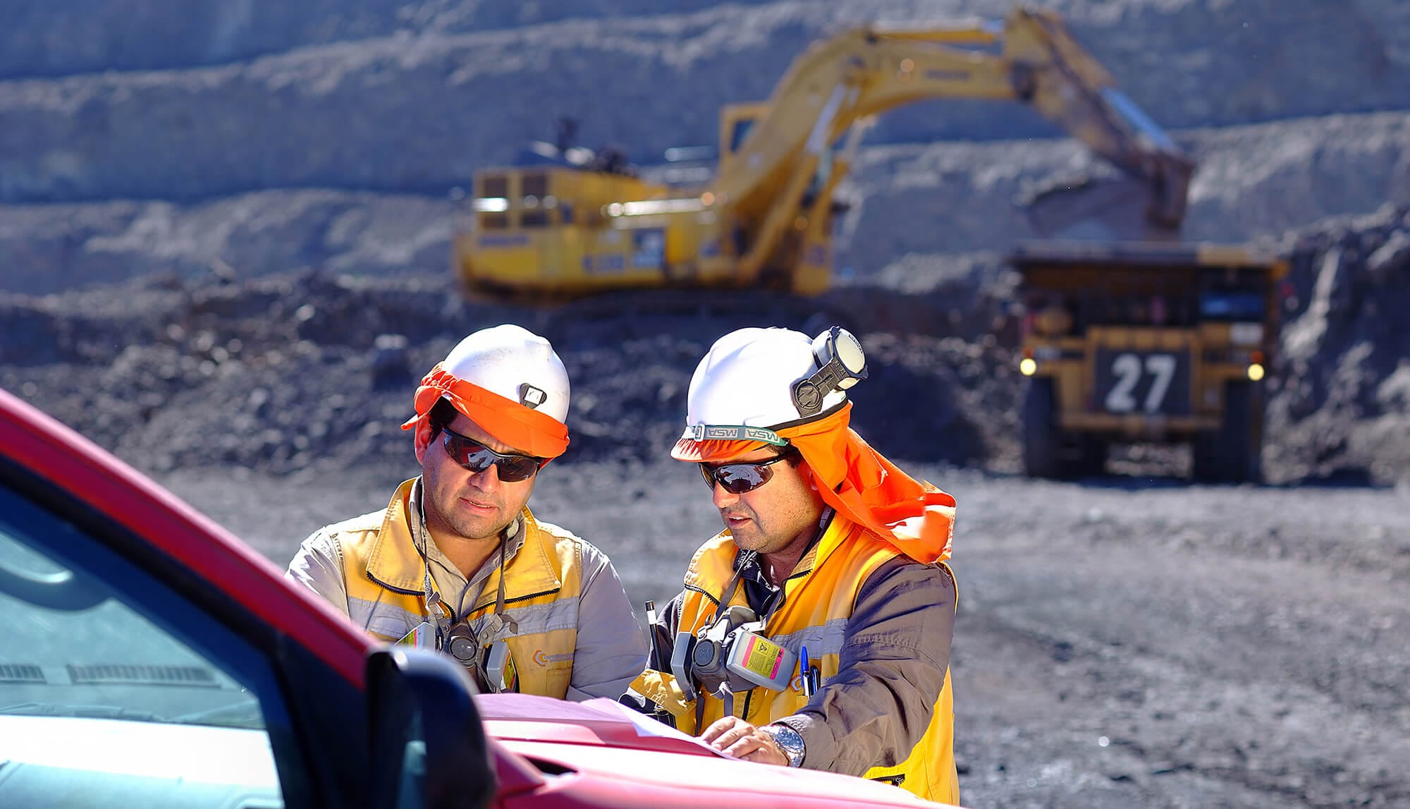 Trabajadores revisando planos en mina a cielo abierto
