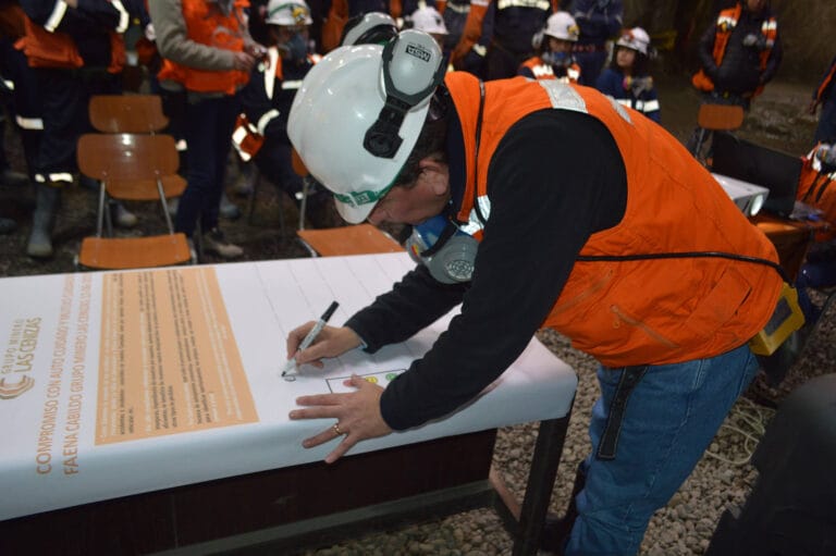 Trabajador con casco firmando compromiso de seguridad