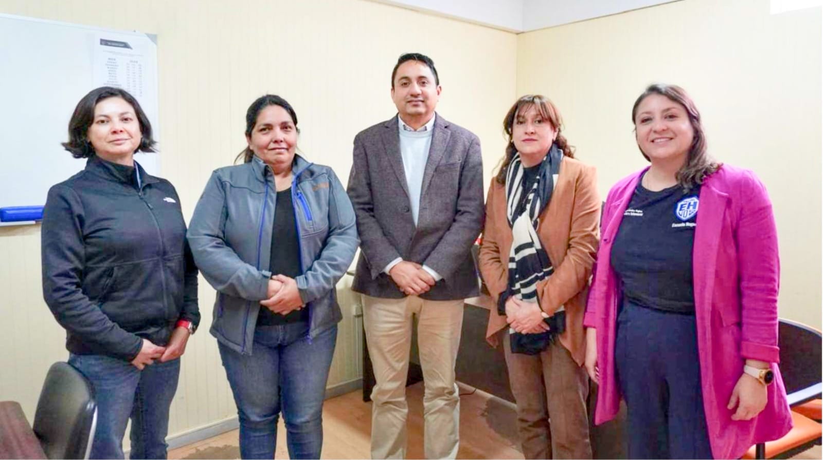 Cinco profesionales posan en una oficina