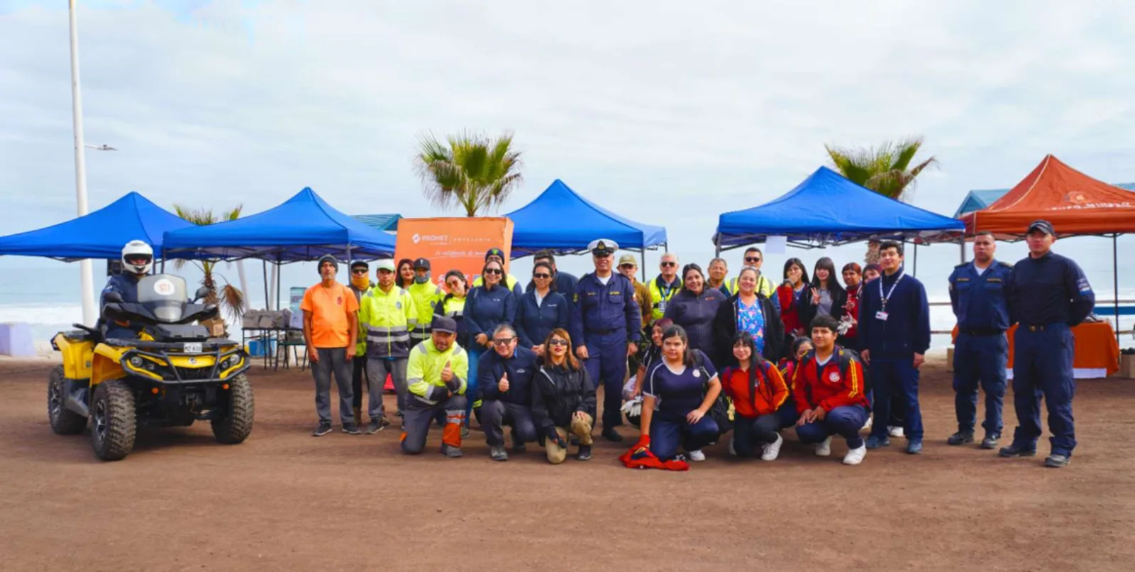 Grupo posando en playa con carpas y quad