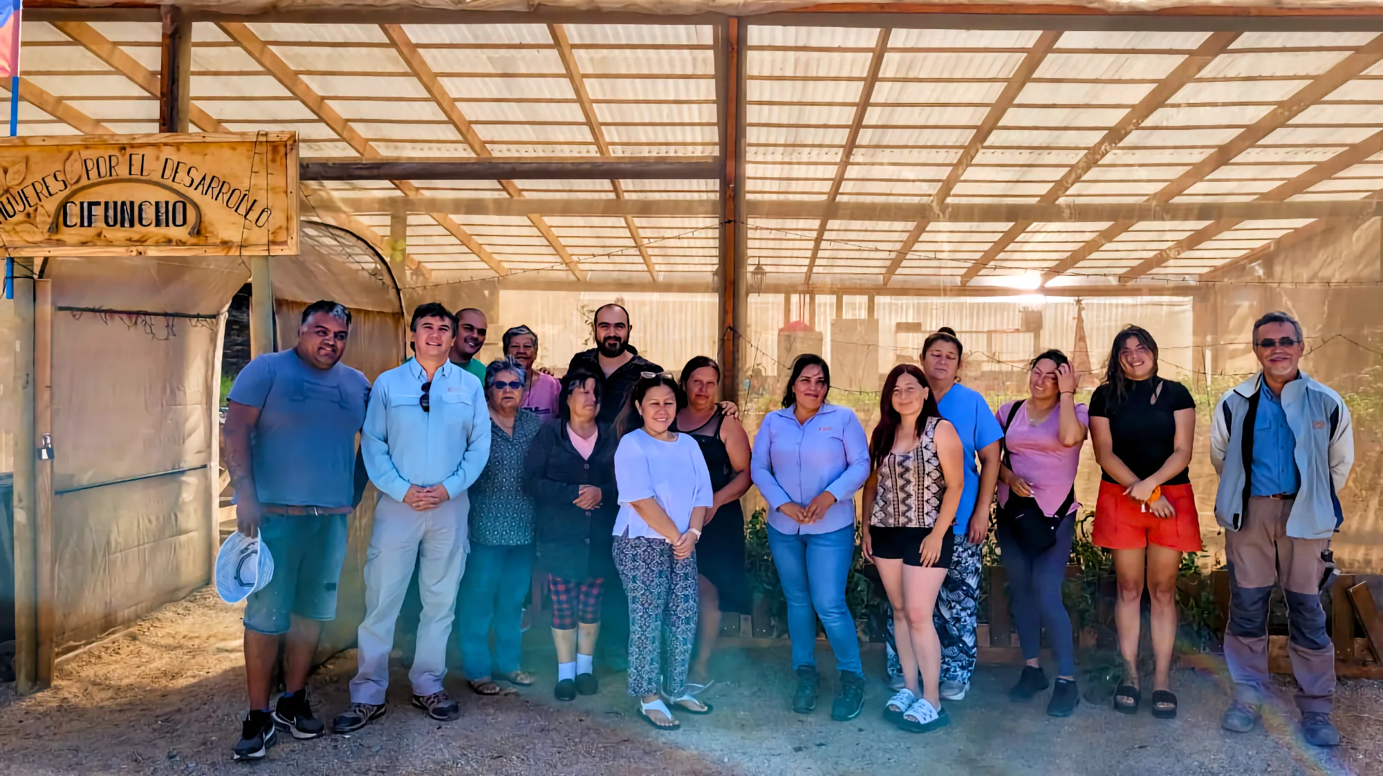 Grupo comunitario posando en invernadero agrícola
