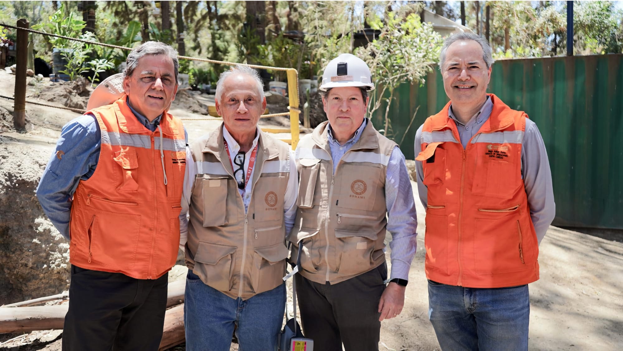 Cuatro trabajadores en obra con chalecos reflectantes