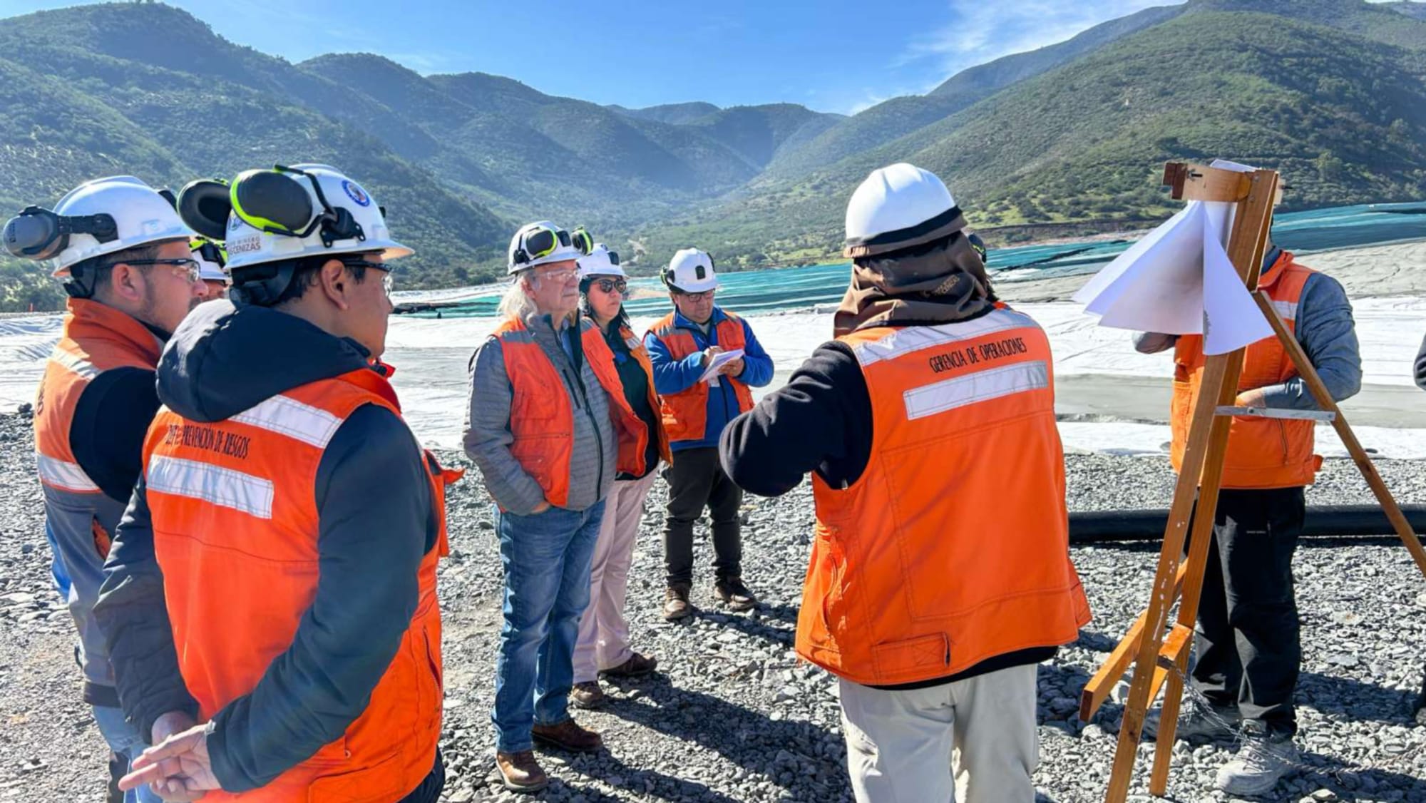 Ingenieros revisando planos en obra minera montañosa